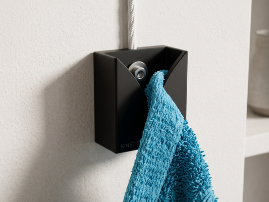 Black wall-mounted towel holder with a blue towel on a light gray wall.